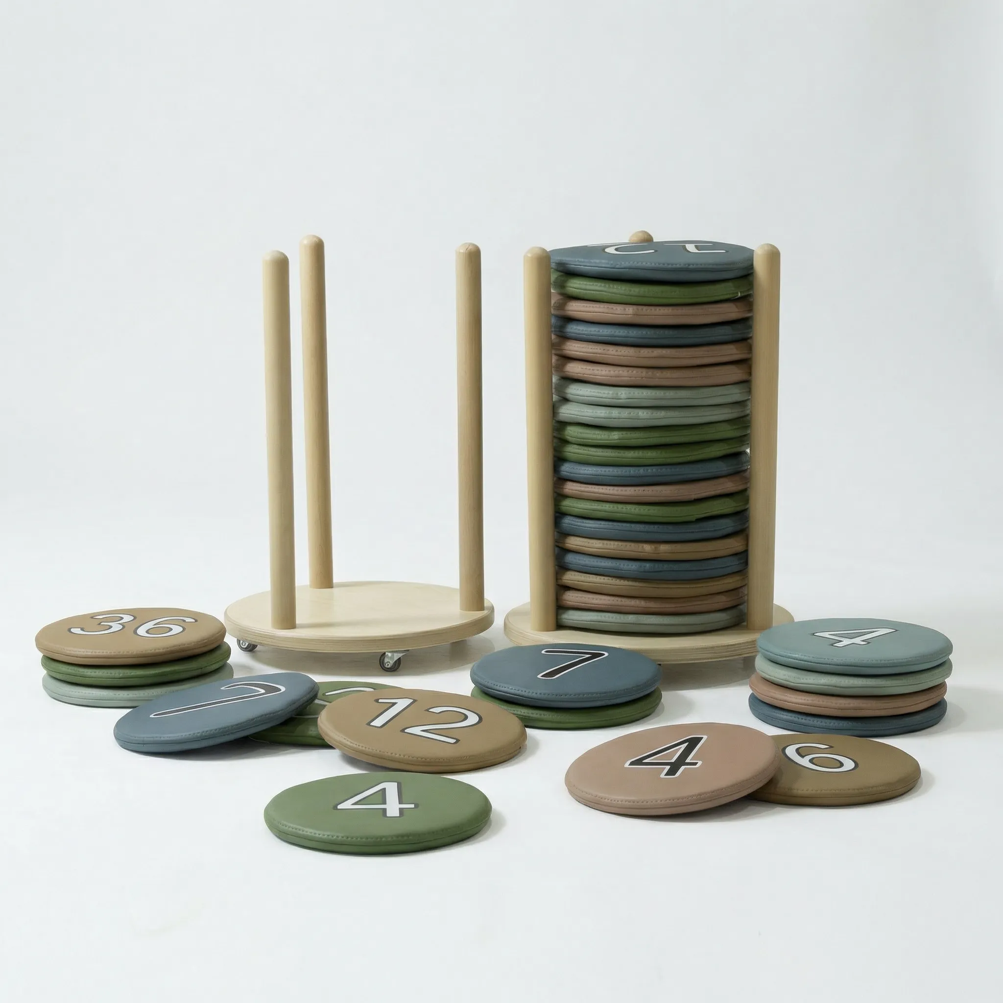 Nummerierte Bodenkissen aus Kunstleder in vier Farben neben Birkenholz-Rollwagen, einzelne Kissen mit sichtbaren Nummern ausgelegt